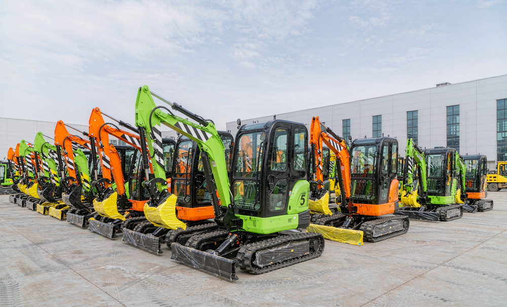 Compact mini excavators lined up in rows at a factory yard awaiting export